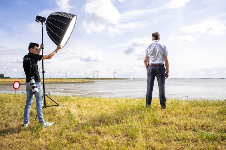 Een man op een dijk en een cameraman die het licht afstelt