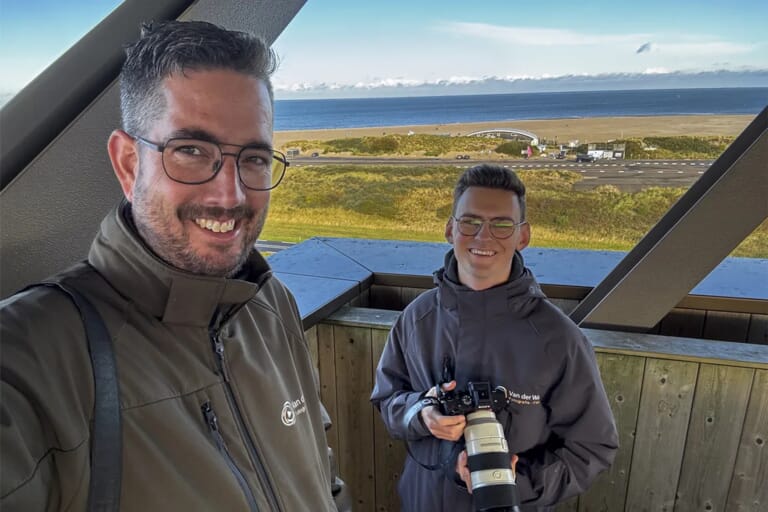 Twee mannen in een toren en strand en water op de achtergrond