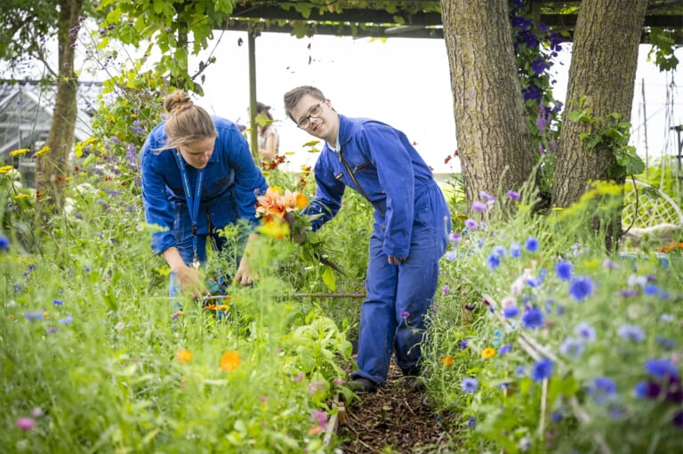 Een jongen en vrouw in een overal in de tuin