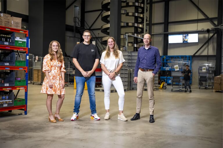 Vier mensen op een rij in een hal