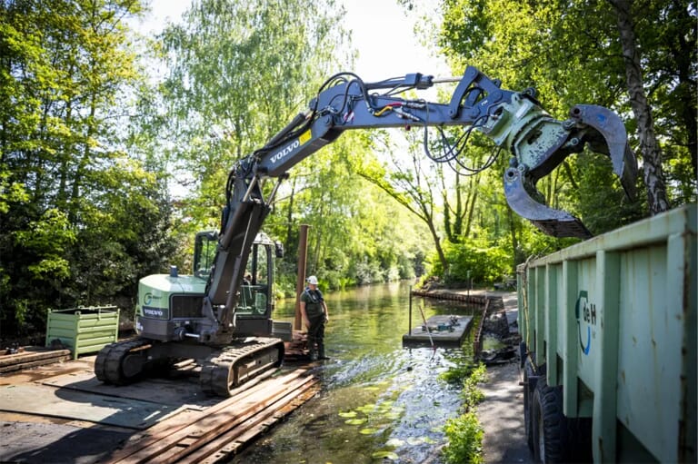 Een hoogwerker op een vlot in een slot met werkmannen