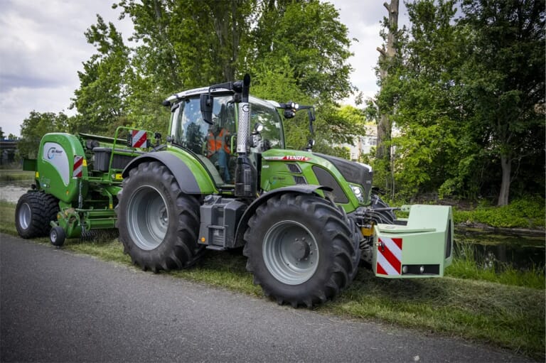 Een trekker met een maaier daarachter