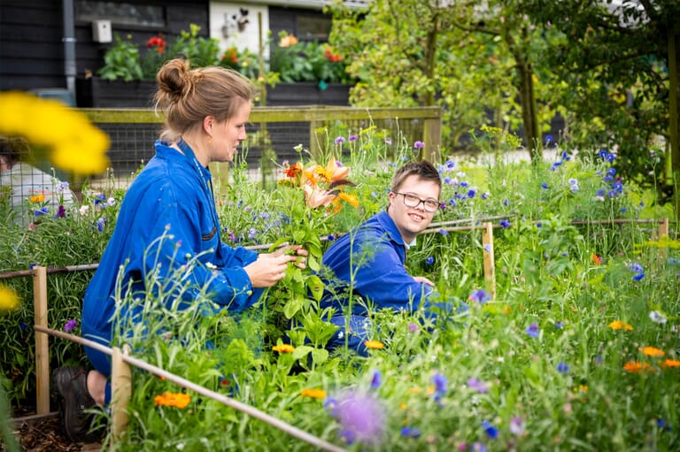 Een vrouw met een jongen in een bloementuin