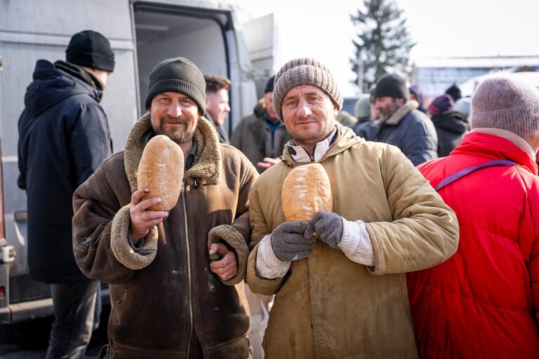Twee mannen met brood in hun handen