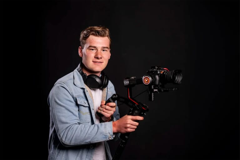 Jongen met een camera en een statief in zijn handen