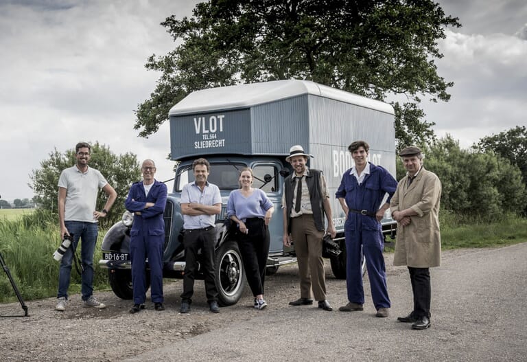 Een groep mensen op een rij voor een bus