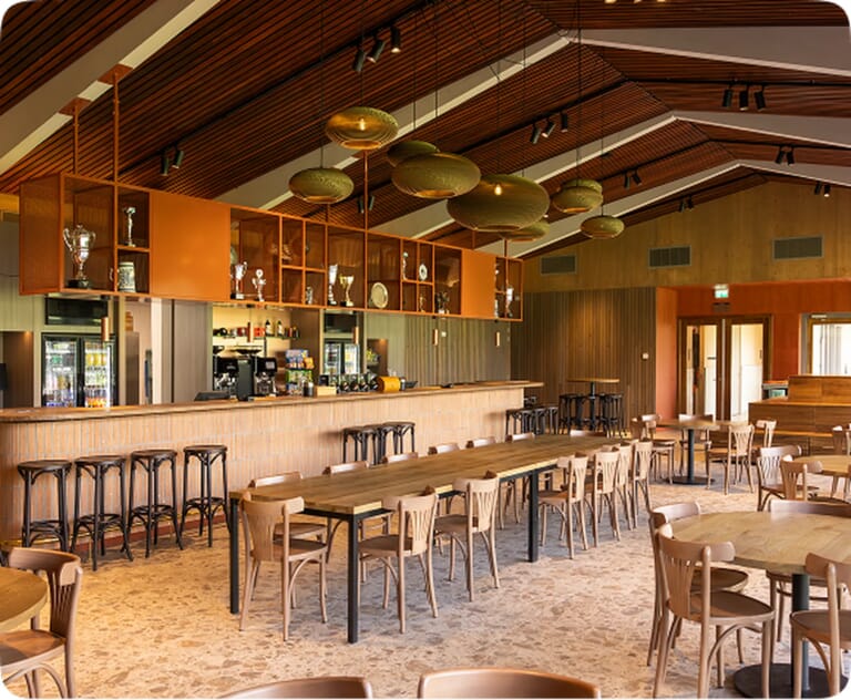 Stijlvol interieur van een bar met houten tafels en barkrukken.