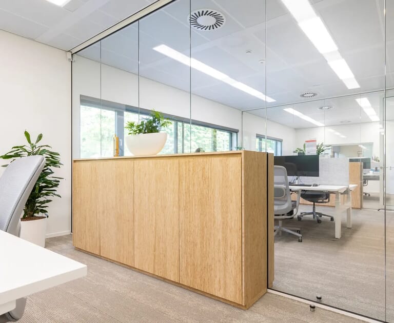 Moderne kantoorruimte met glazen wanden en houten kasten