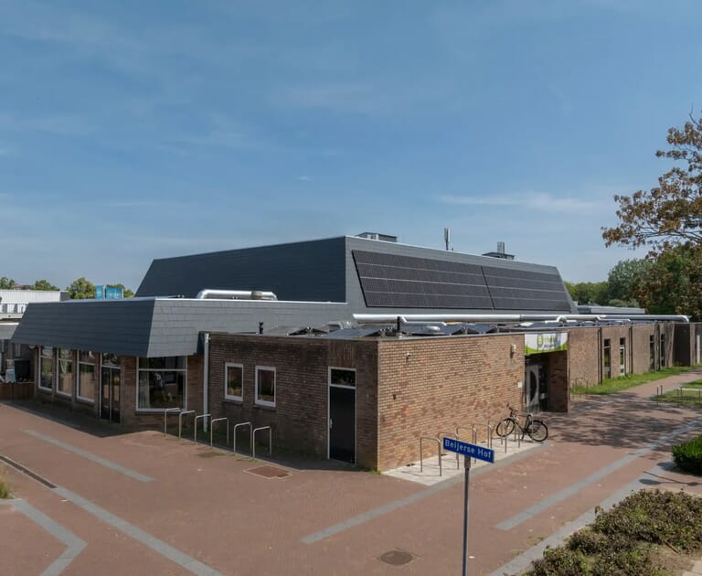 Bakstenen gebouw met zonnepanelen en fietsen
