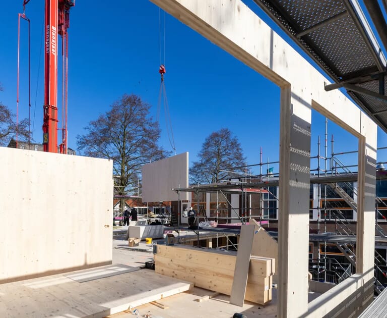 Bouwplaats met houten structuren en hijskraan
