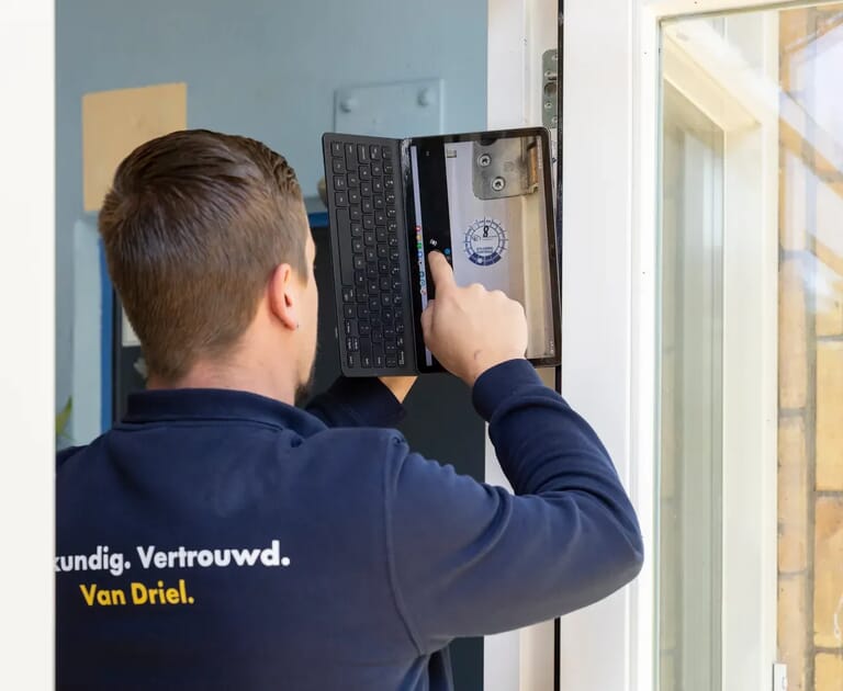 Monteur gebruikt tablet bij deurinspectie.