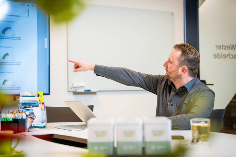 Medewerker van Verhelst die wijst naar een bord tijdens uitleg over administratie uitbesteden