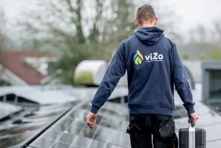 Man op het dak met zonnepanelen