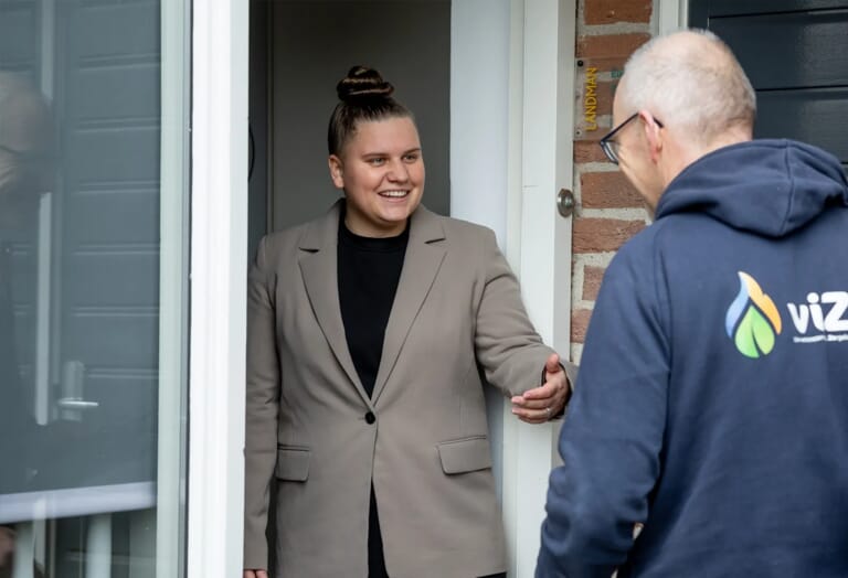 Vrouw in een deurgat met een man voor de deur met een tas