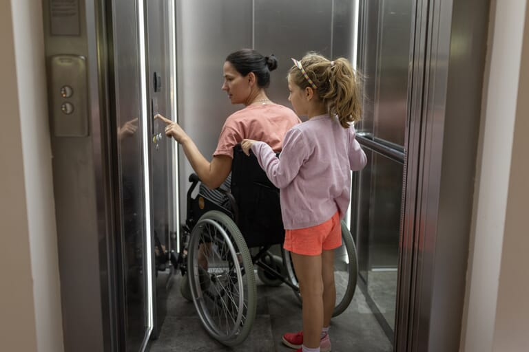 vrouw-in-rolstoel-met-dochtertje-gebruiken-liftoplossing
